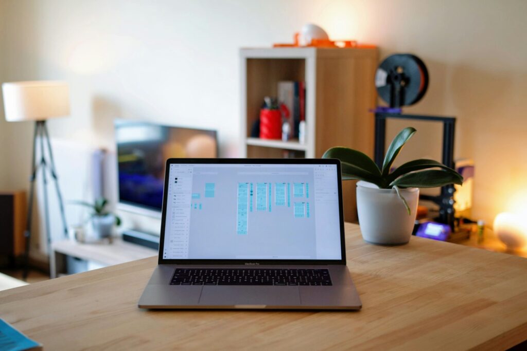 Laptop mit Website-Entwurf auf einem Holzschreibtisch in einem hellen Büro